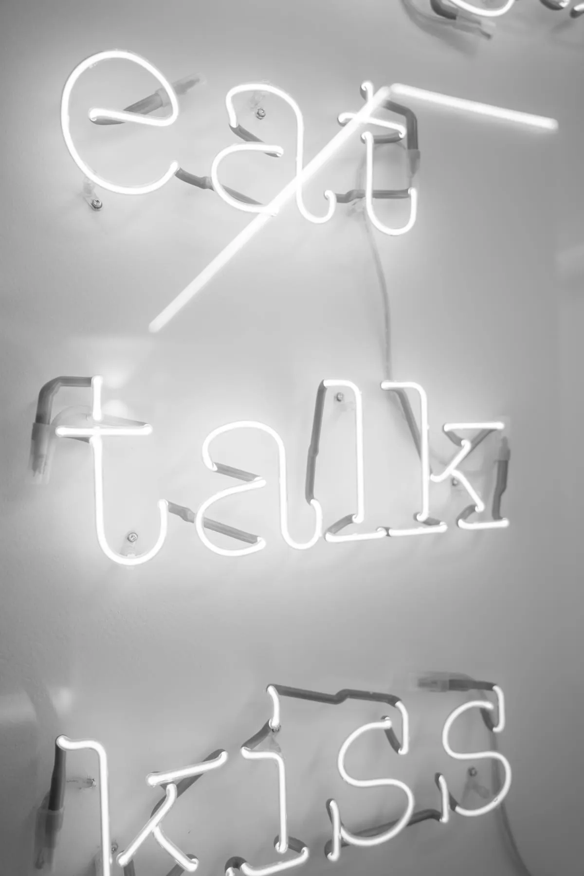 Leuchtschrift eat talk kiss im Gang